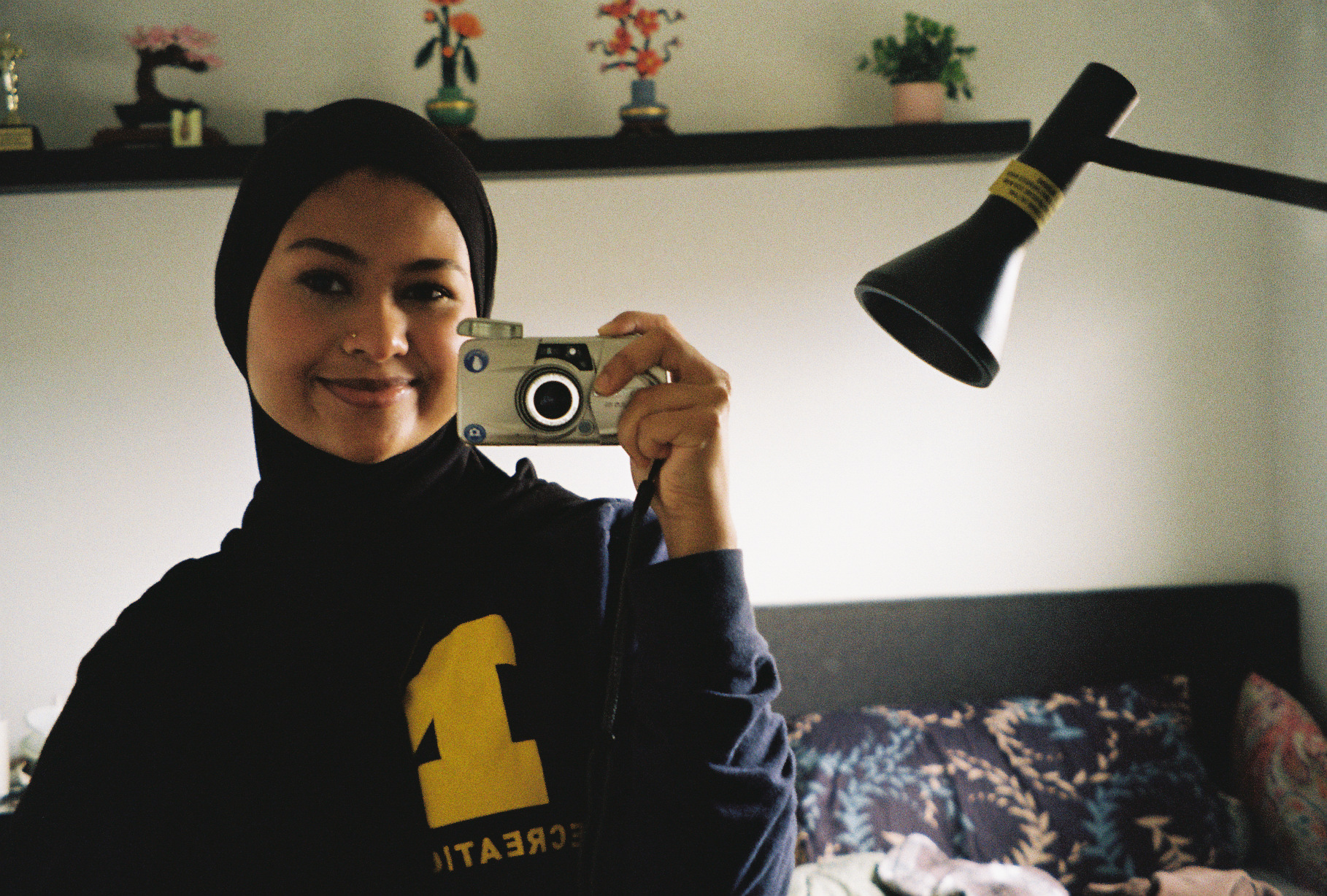 Tabassum Chowdhury taking a mirror selfie with a film camera