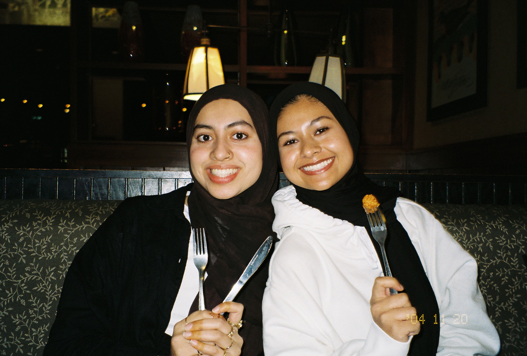 Two more girl friends at Pizza House holding silverware up and smiling